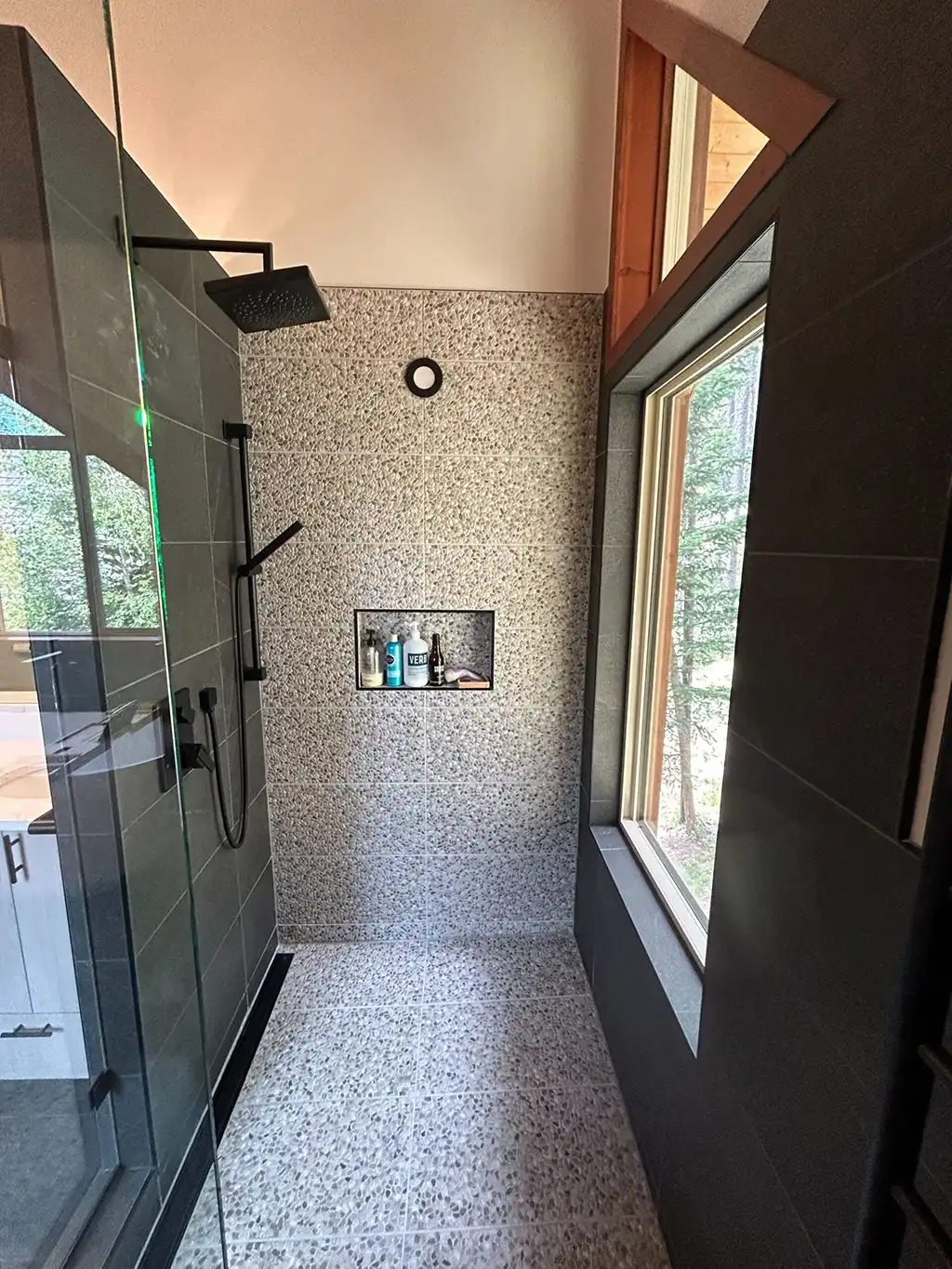 tiled shower with glass doors and window done by Vision Project Services