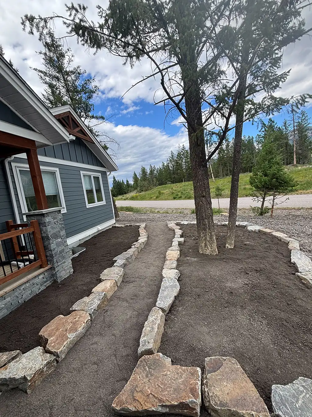dirt walkway lined with rocks and plant beds